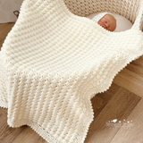 Baby in a crib with blanket