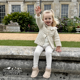 Child wearing a beige crocheted cardigan