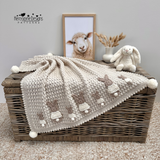 A beige crochet blanket with bunny appliques added