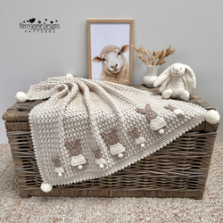A beige crochet blanket with bunny appliques added