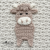 a close up photo of the highland cow applique on a textured blanket 