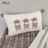 three highland cow appliques sewn onto a white pillow 