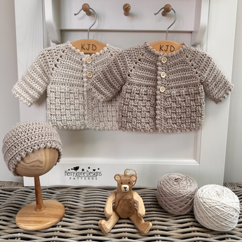 Basket weave cardigan and hat displayed on a wicker trunk 