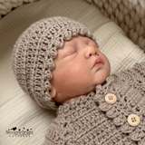 baby doll wearing a KJD cardigan and hat 
