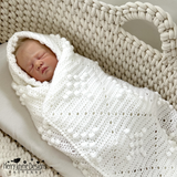 Baby wrapped in a christening blanket