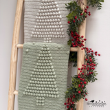 Two christmas tree bobble blankets draped from a ladder 