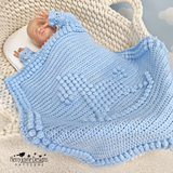 A Rocking horse blanket over a baby n a moses basket 