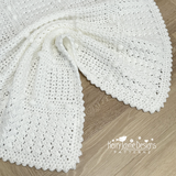 White crocheted blanket on a wooden surface with Kerry Jayne Designs logo.