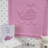 A pink crocheted whale blanket 