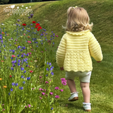 Child in a yellow crochet cardigan walking through a field of flowers with 'Kerry Jayne Designs' branding.