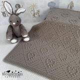 Gray knitted blanket with a soft toy on a light background