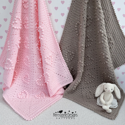 Pink and gray crocheted blankets with a white stuffed bunny toy on a heart-patterned background.