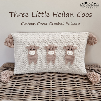 Crocheted rectangular cushion cover with three small cow motifs in beige and white, displayed on a woven wicker surface. Text at the top reads 'Three Little Heilan Coos' and 'Cushion Cover Crochet Pattern,' with the Kerry Jane Designs Patterns logo in the upper right.