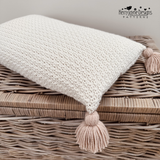 Crocheted cushion with four tassels and a button closure at the back, a crochet pattern by Kerry Jayne Designs 