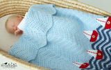Baby in cot with boat blanket